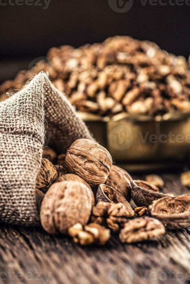 Walnut kernels whole walnuts in burlap sack and vintage bowl photo