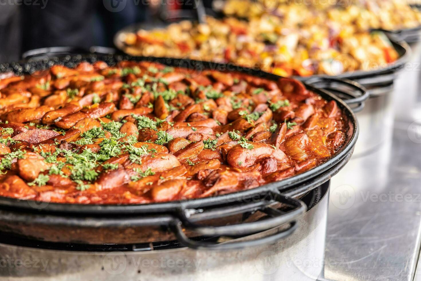 Large hot pan full of wintery comfort food in a form of suasage and tomato paste stew photo