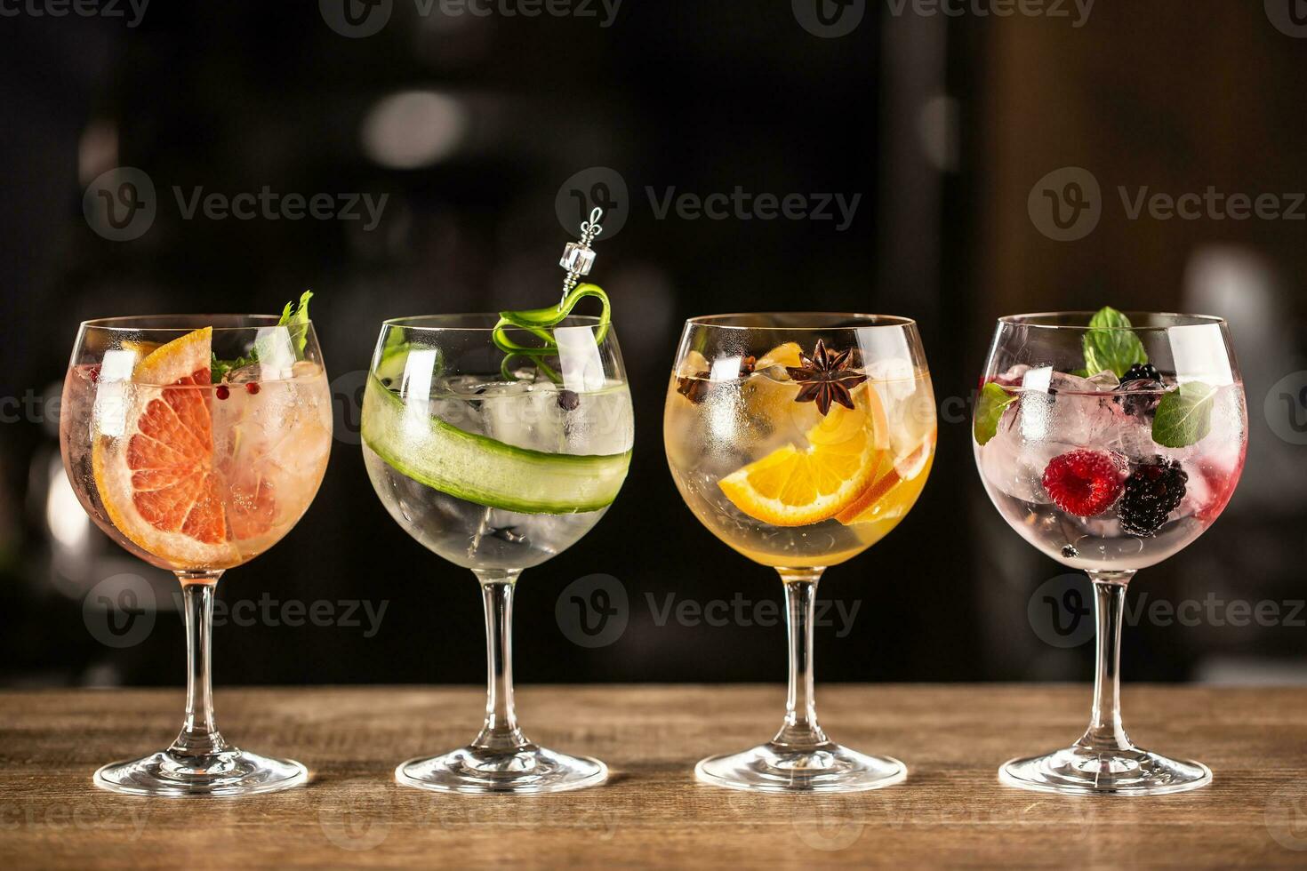 Gin tonic long drink as a classic cocktail in various forms with garnish in individual glasses such as orange, grapefruit, cucumber or berries photo