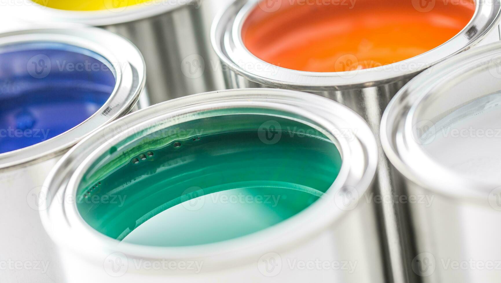 Full of multicolored paint cans on white table photo