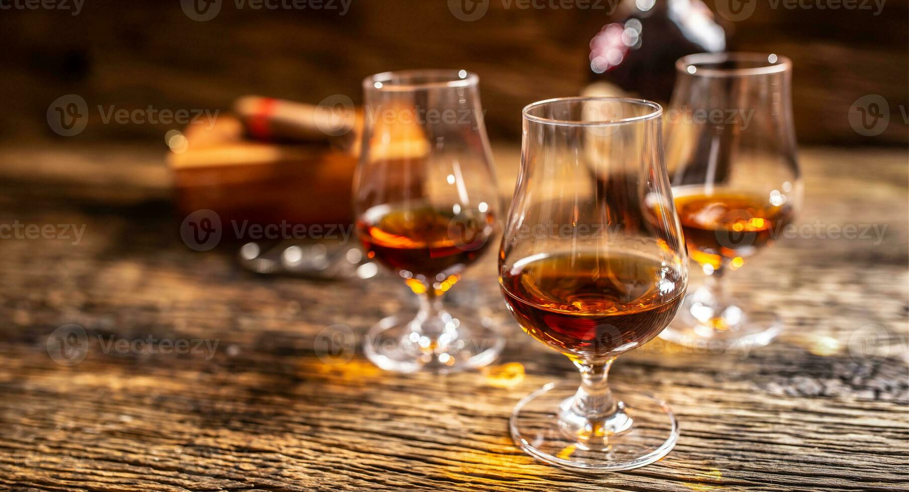 Caribbean rum in modern glasses with a bottle of rum and a cigar in the background photo