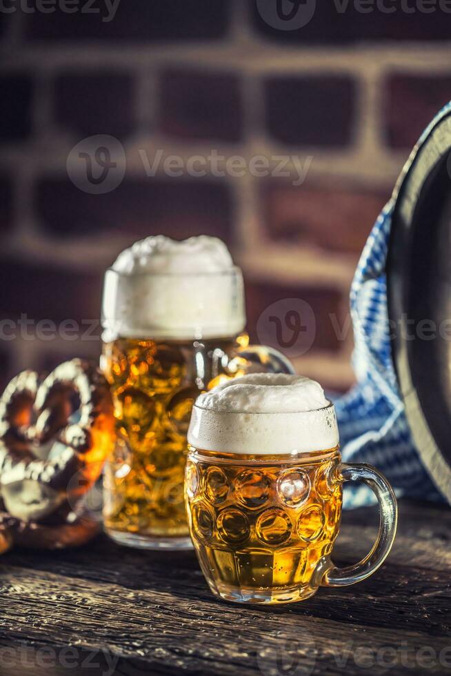 Oktoberfest large and small beer with pretzel wooden barrel and blue tablecloth photo