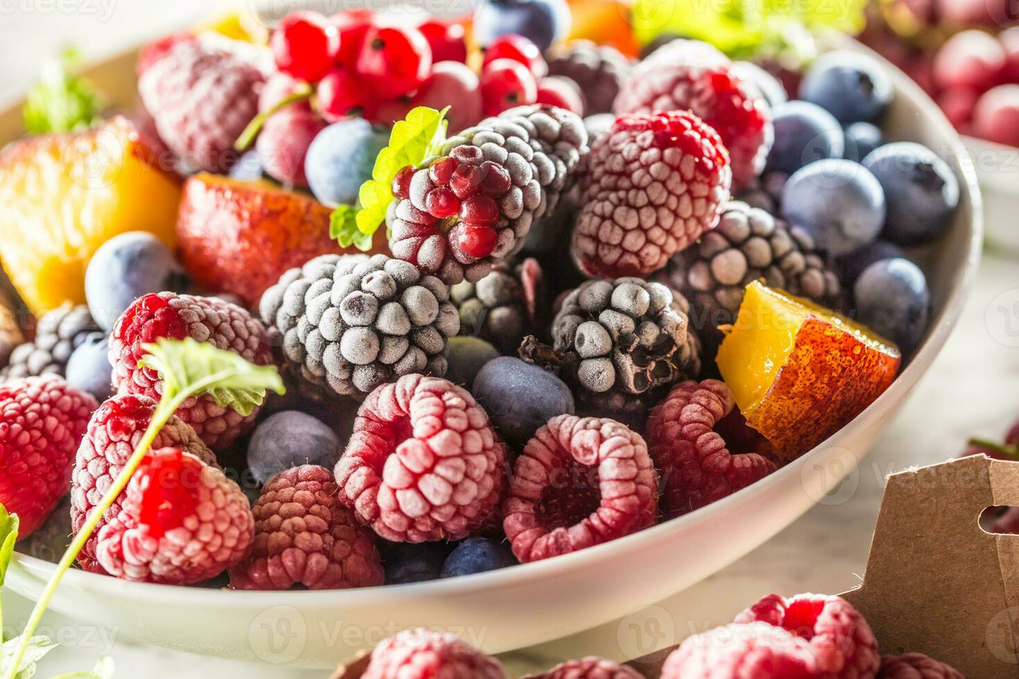 Frozen fruits blueberries blackberry raspberry red currant peach and herbs melissa photo