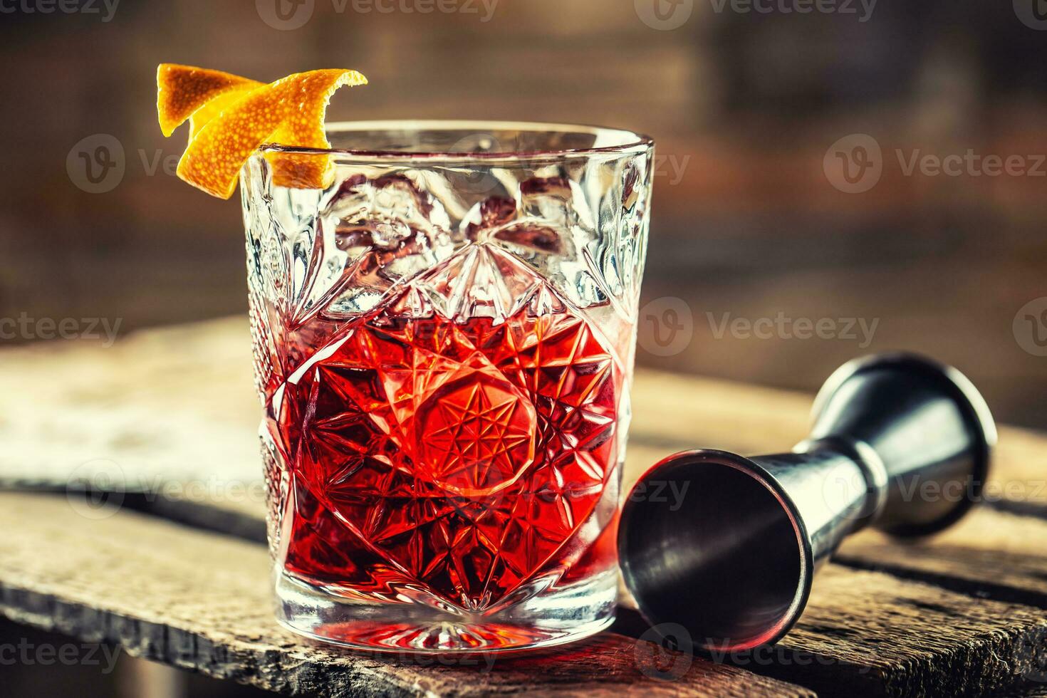 cóctel negroni en un antiguo de madera tablero. bebida con Ginebra, Campari martini rosso y naranja foto