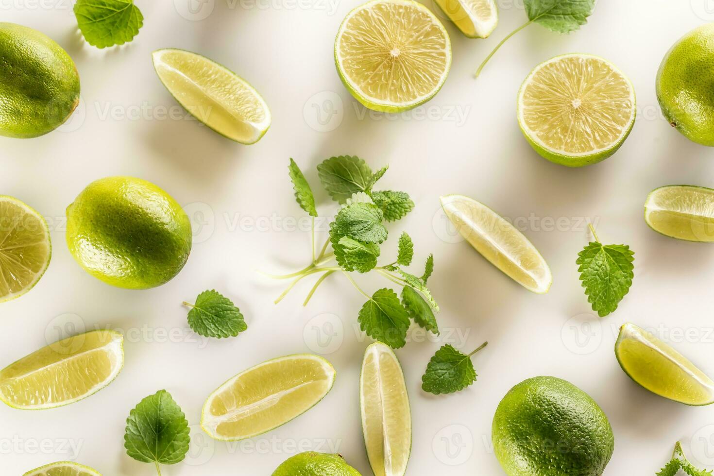 Freshly cut lime and mint leaves on a white background photo