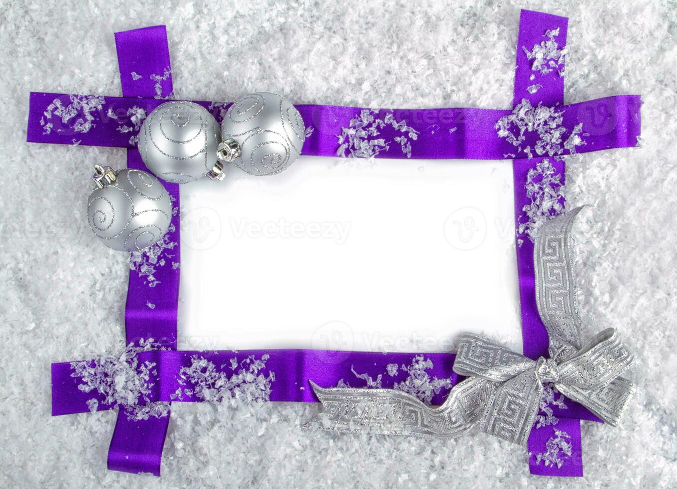 Christmas concept ready to edit. Purple ribbon in snow with silver balls and silver ribbon photo