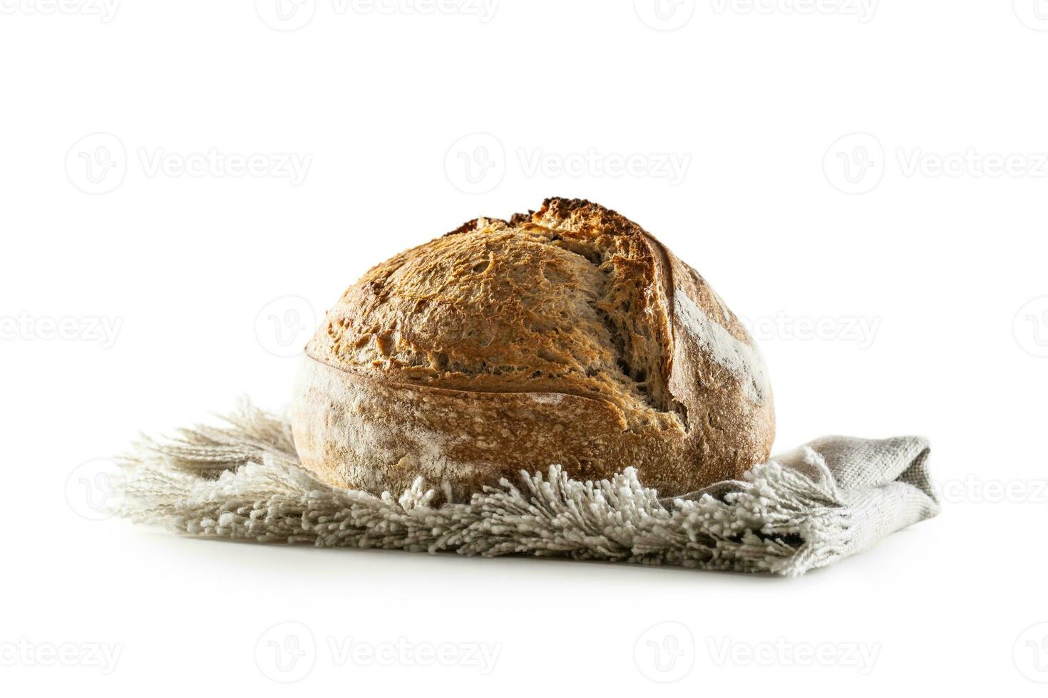 Isolated freshly baked crunchy yeast bread loaf lying on the flax dish cloth photo