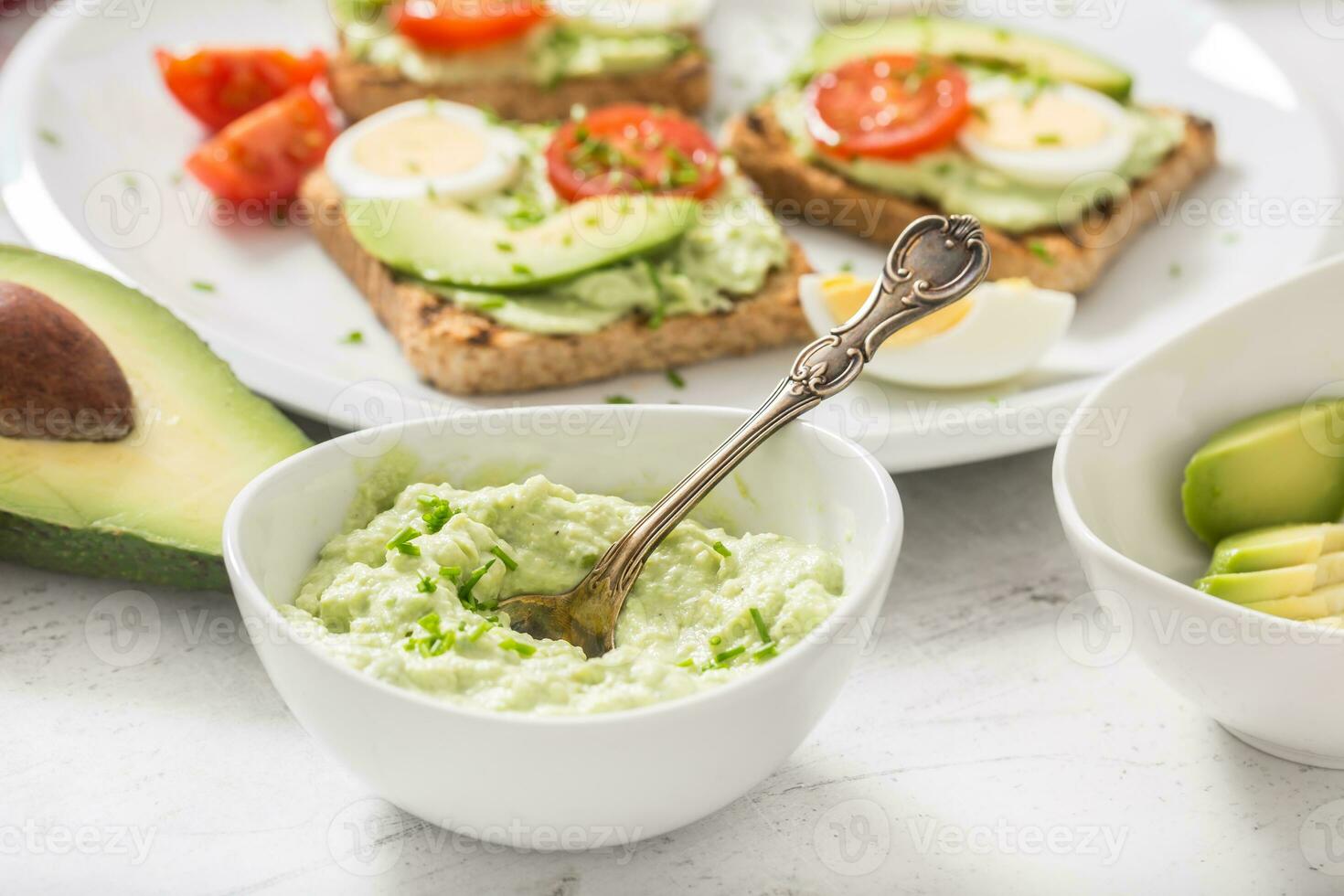 Avocado spread guacamole toasts egg tomato chives as breakfast meal or appetizer photo