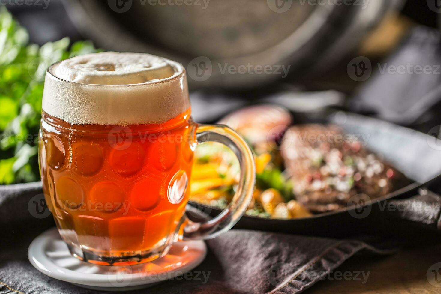 Glass of red beer in pub or restavurant on table with delicoius food photo