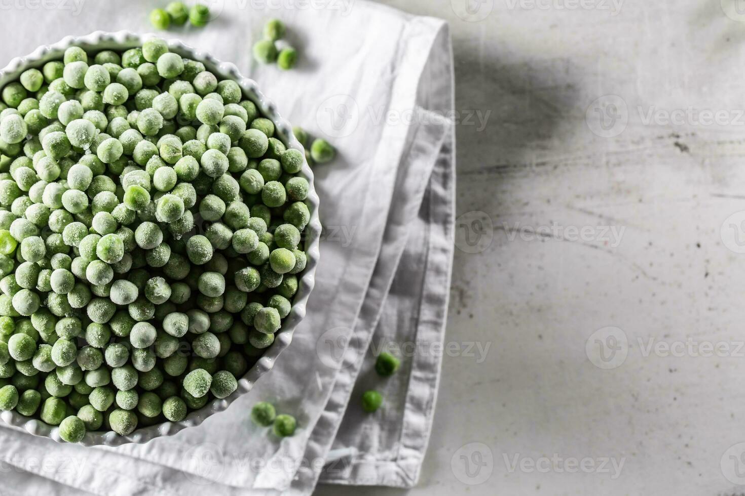 Frozen peas in a white porcelain bowl. photo