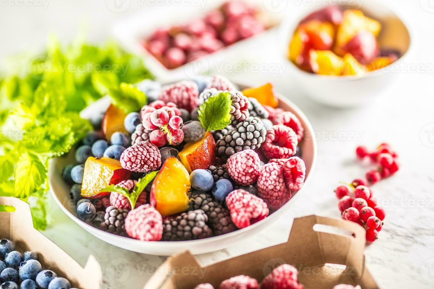Frozen fruits blueberries blackberry raspberry red currant peach and herbs melissa photo