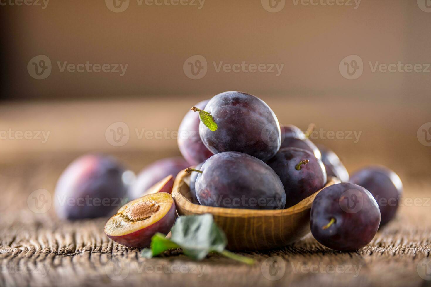 Plums. Fresh juicy plums in a bowl on a wooden or concrete board photo