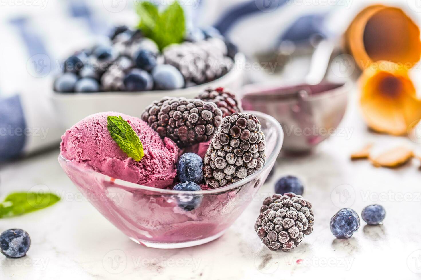 Blueberry and blackberry ice cream in bowl with frozen fruits photo