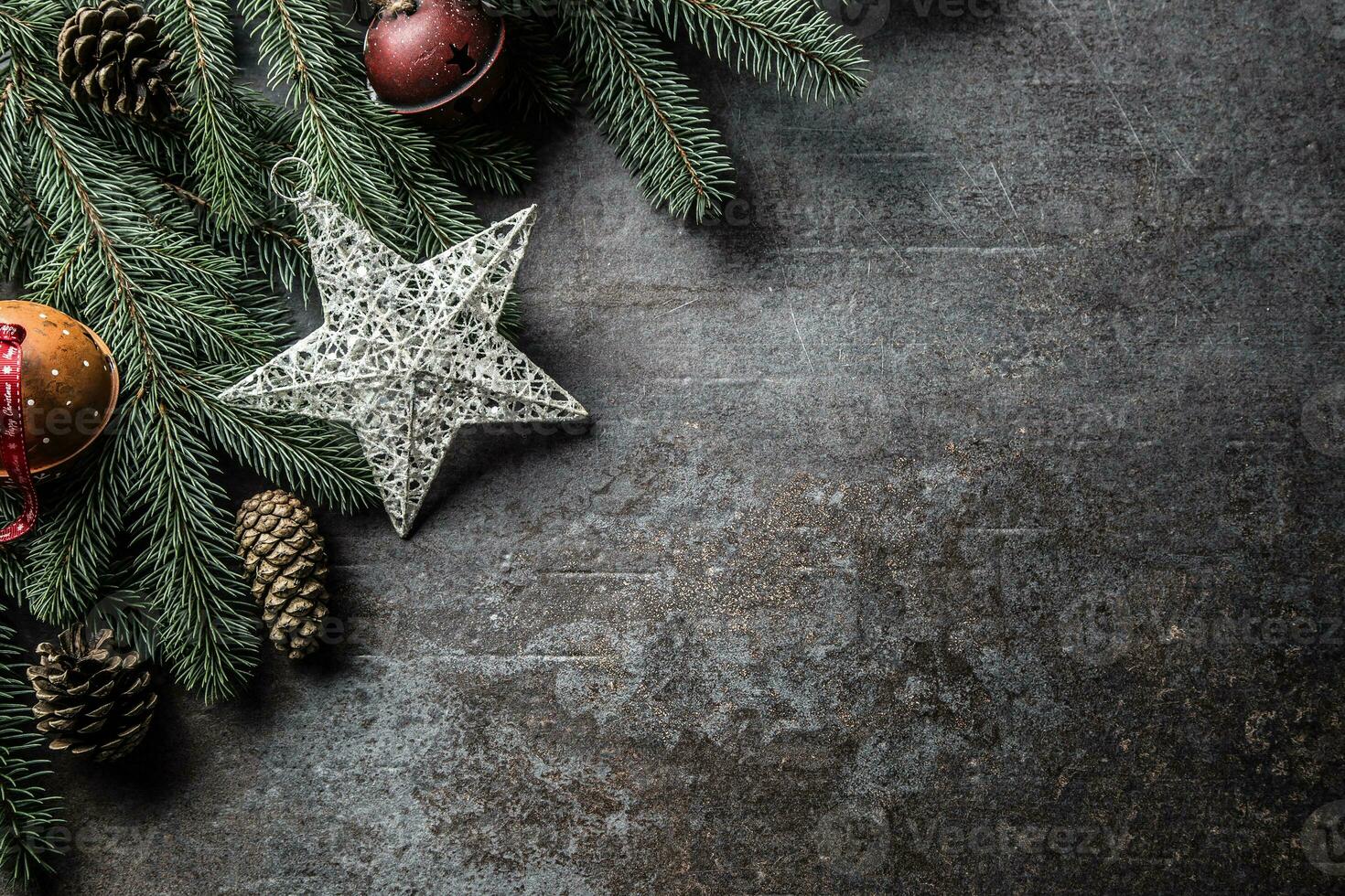 Top of view christmas star decorations jingle bells fir tree pine cones on free concrete background photo