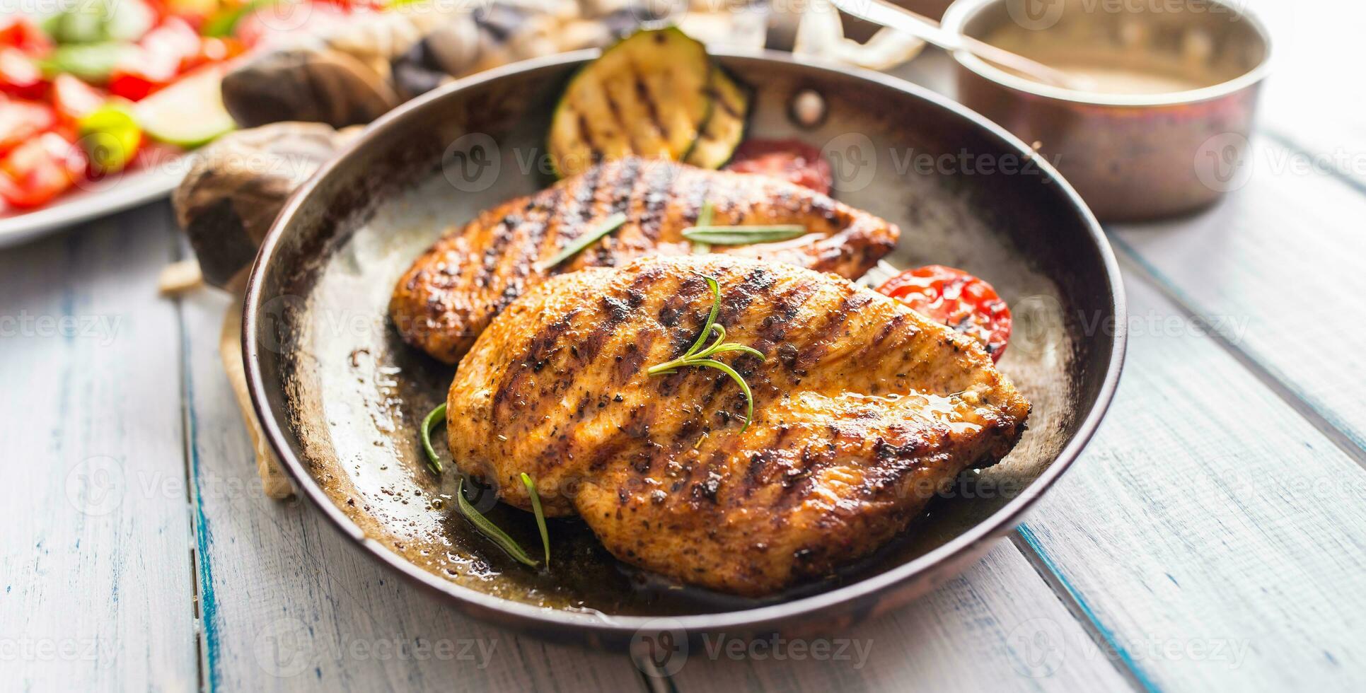 Grilled chicken breast in old frying pan. photo