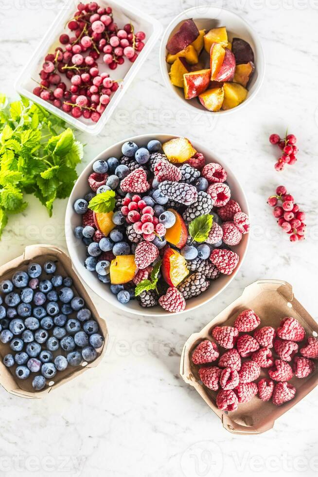 Frozen fruits blueberries blackberry raspberry red currant peach and herbs melissa photo