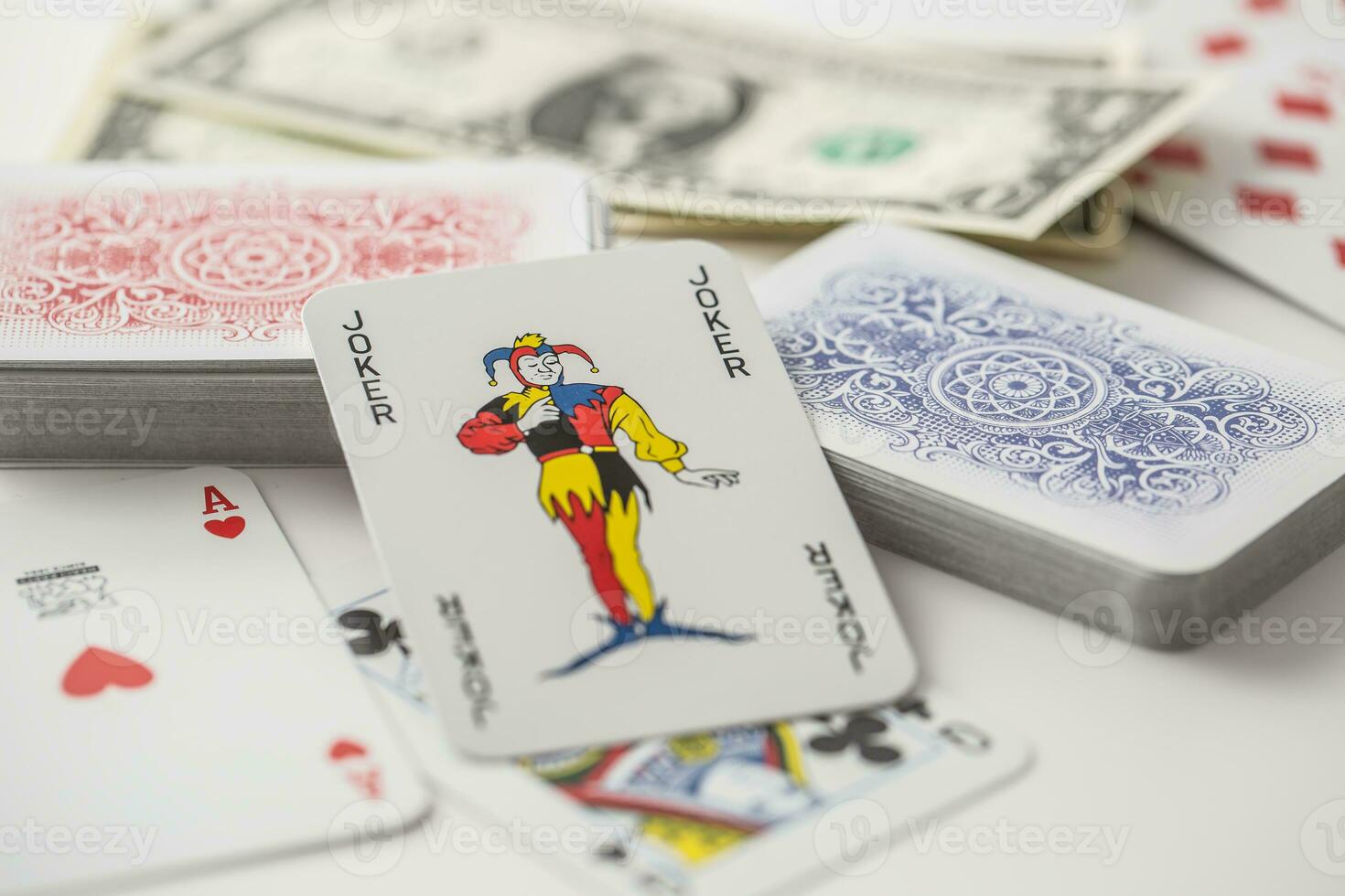 Joker card in the center of various playing cards turned both ways photo