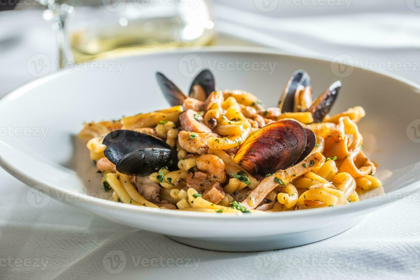 Italian pasta with mussels and prawn in white plate photo