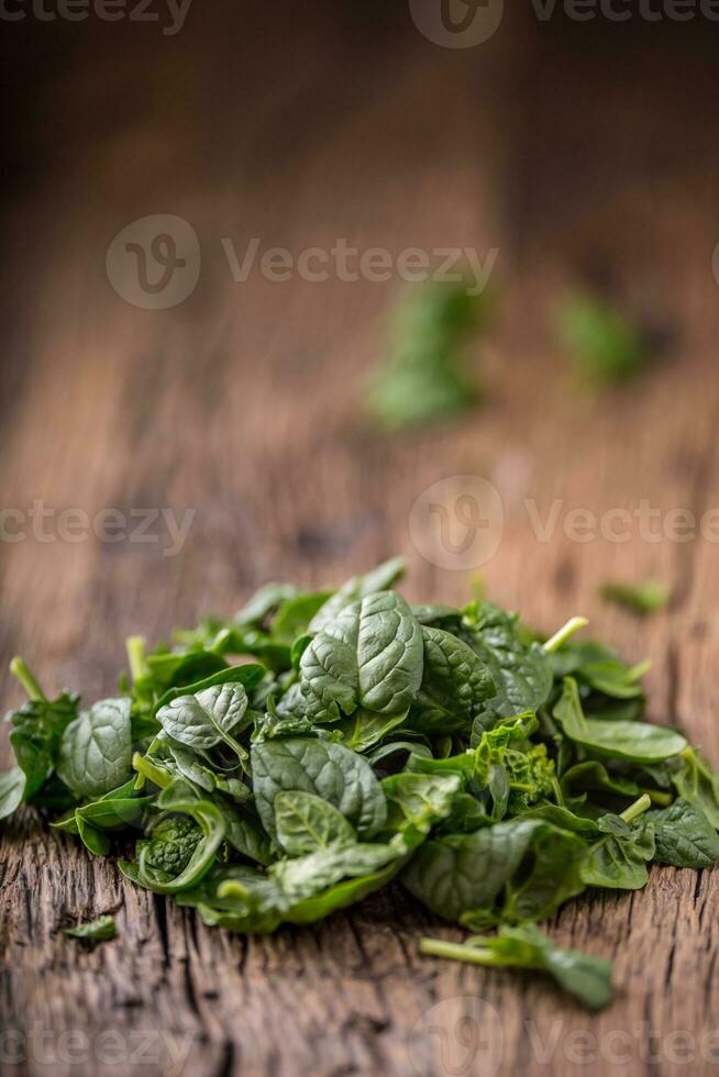 Spinach leaves.Fresh spinach leaves in retro bowl on oak wood board. Selective focus. photo