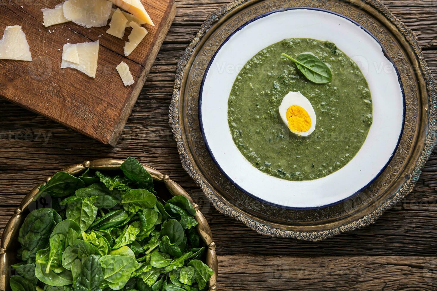 Spinach soup. Portion spinach soup with egg and cheese parmesan in retro style. photo