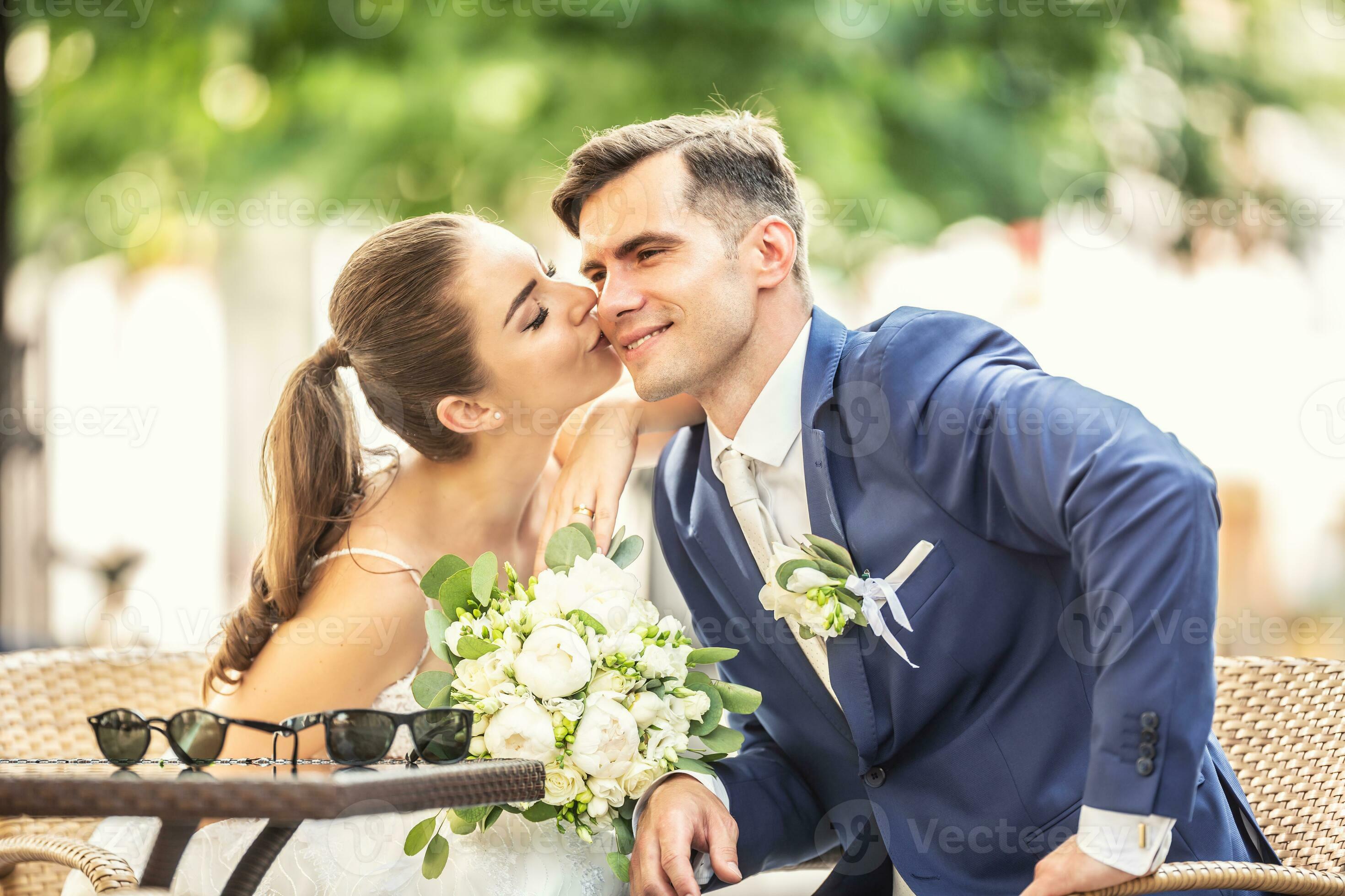 Loving bride kissing her charming huband. They wear wedding robes