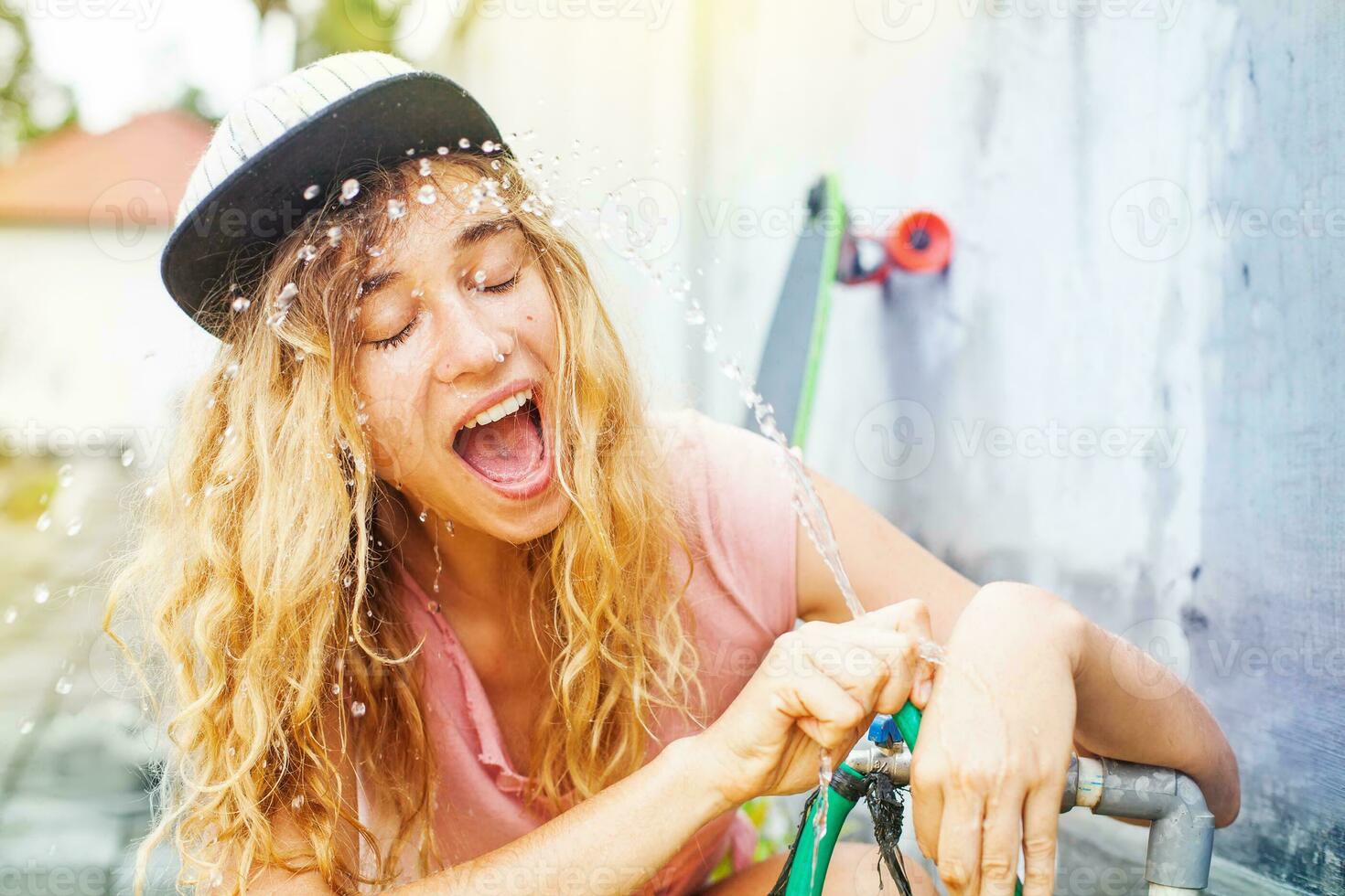 un mujer es pulverización agua en su cara foto
