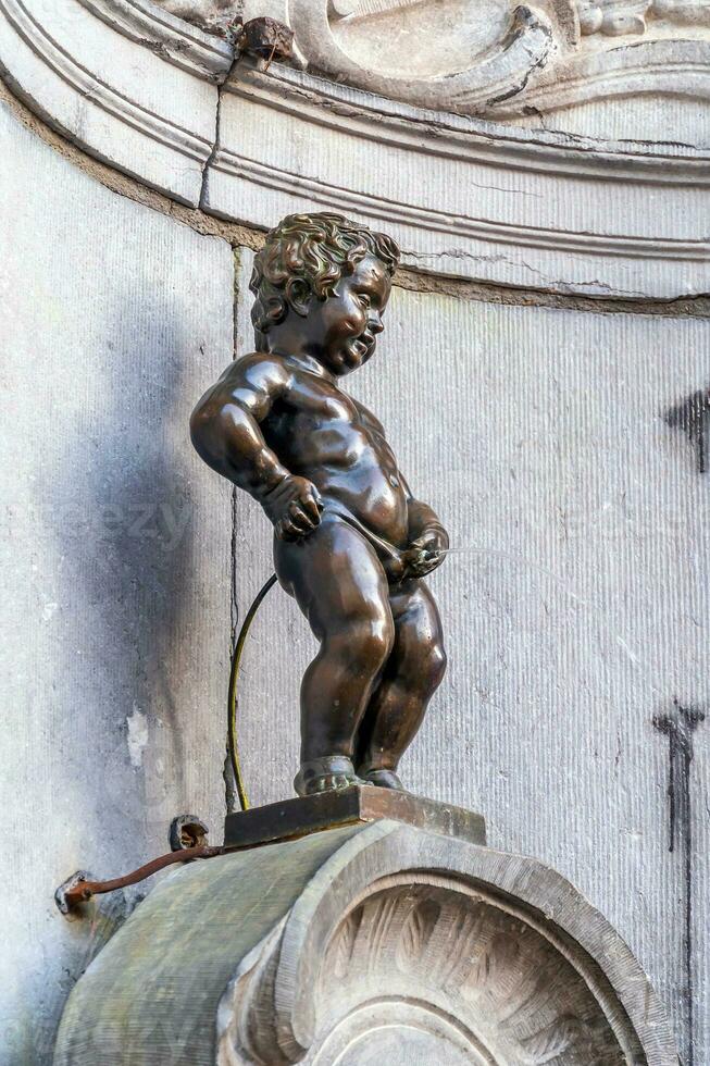 Manneken Pis Little man Pee or le Petit Julien, a very famous bronze sculpture landmark in Brussels photo