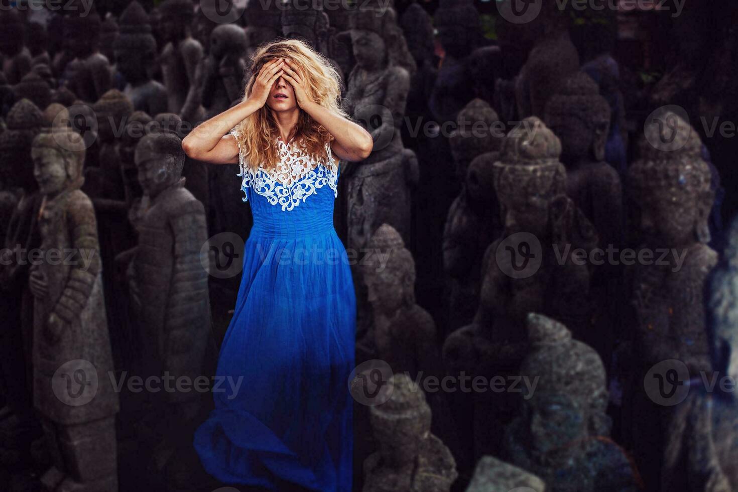 un mujer en un azul vestir rodeado por estatuas foto