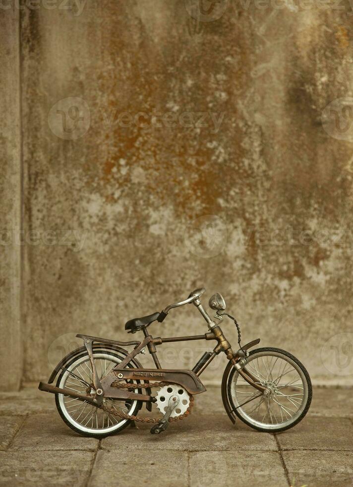a bicycle is parked against a wall photo