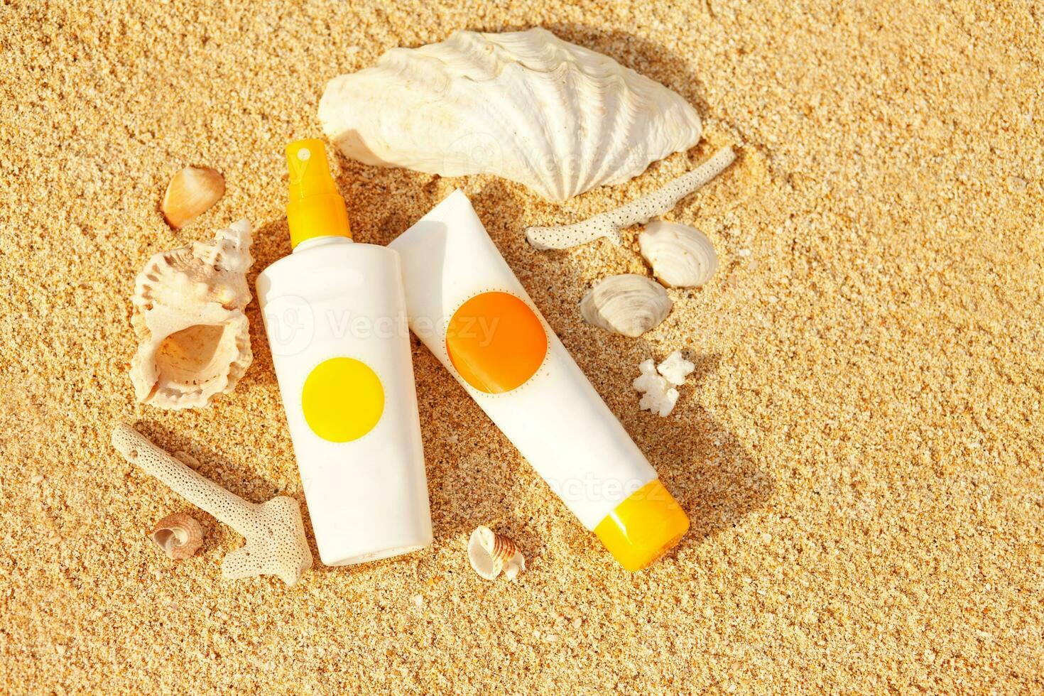 sunscreen and other products on the sand photo