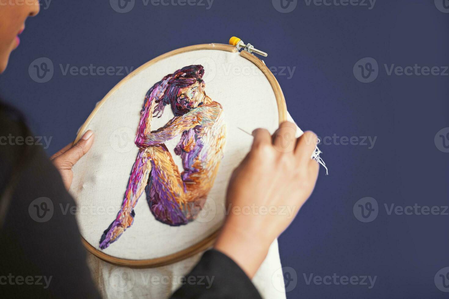 a woman is holding a cross stitch of a woman photo