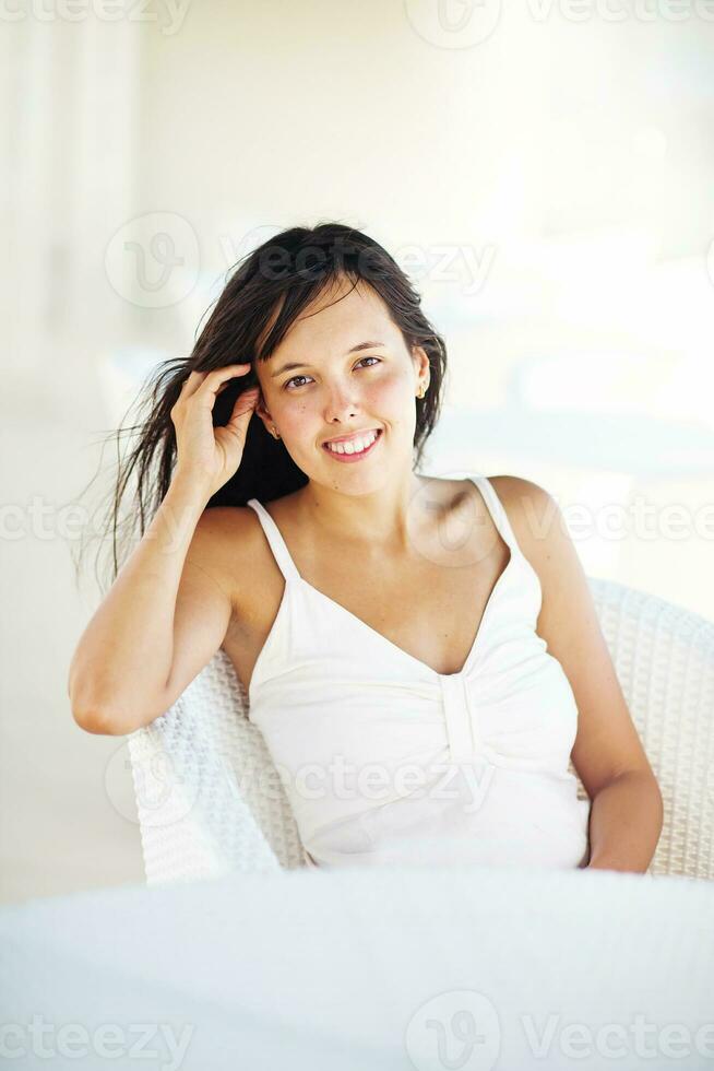 a woman sitting on a white chair photo