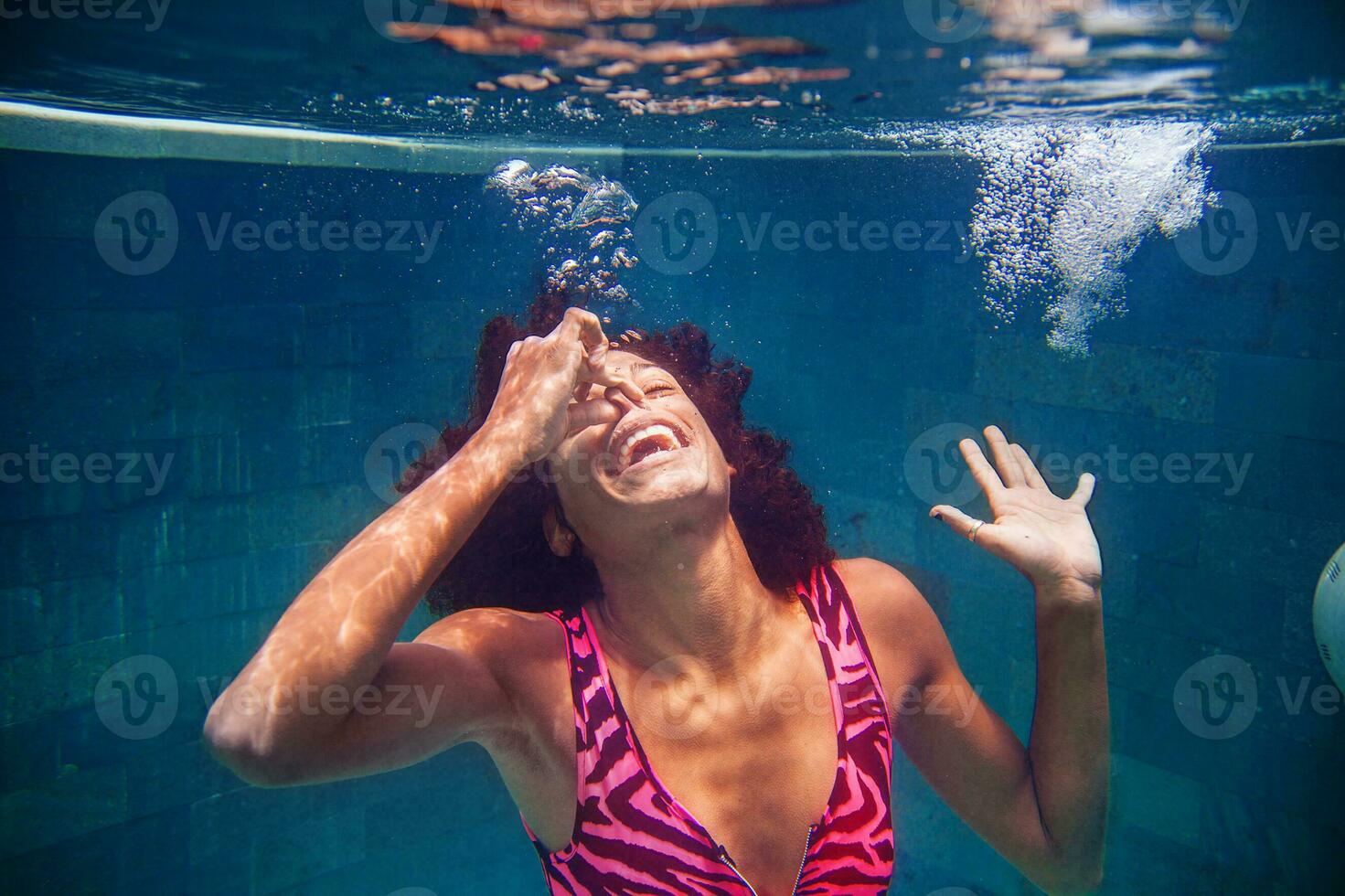 a woman in a pink swimsuit is underwater photo