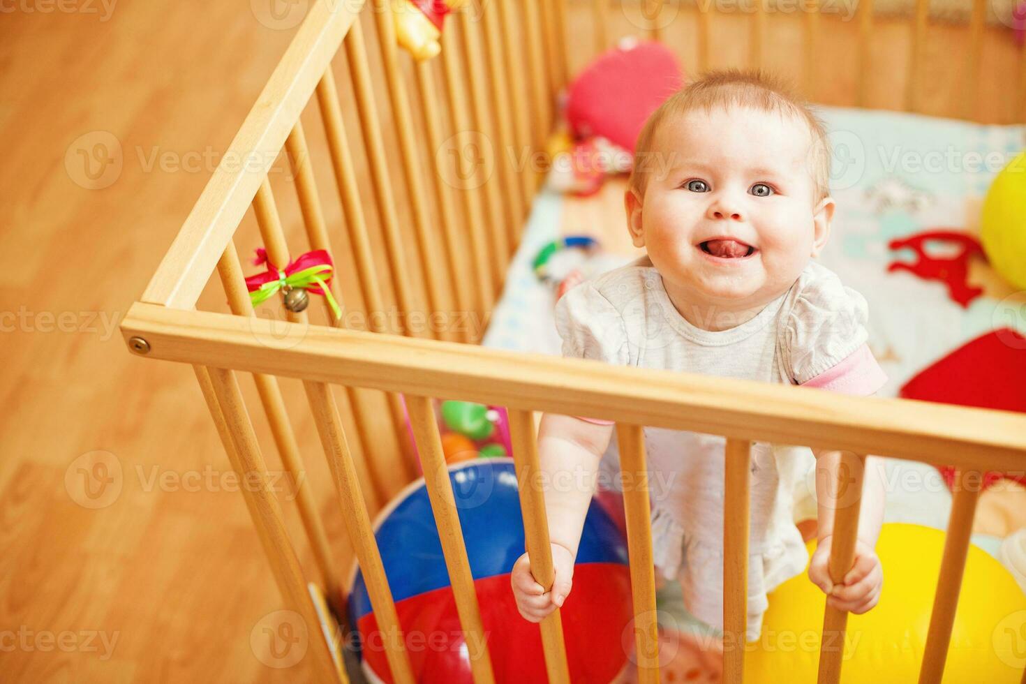 a baby in a crib with toys photo