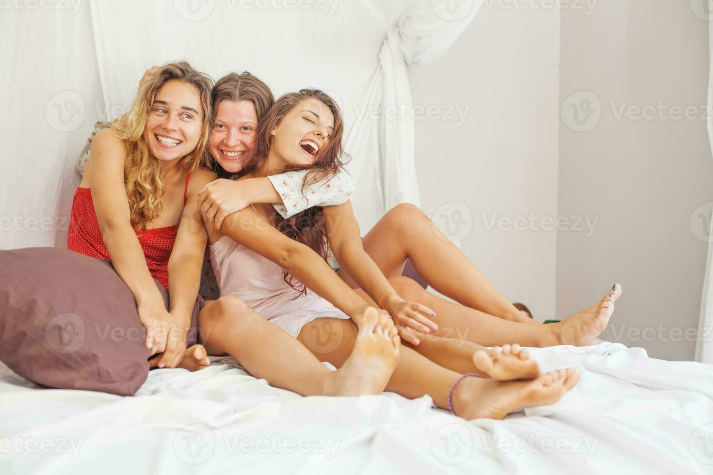 three girlfriends at home in a bed photo