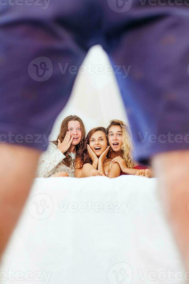 a man is standing behind a woman and two girls photo