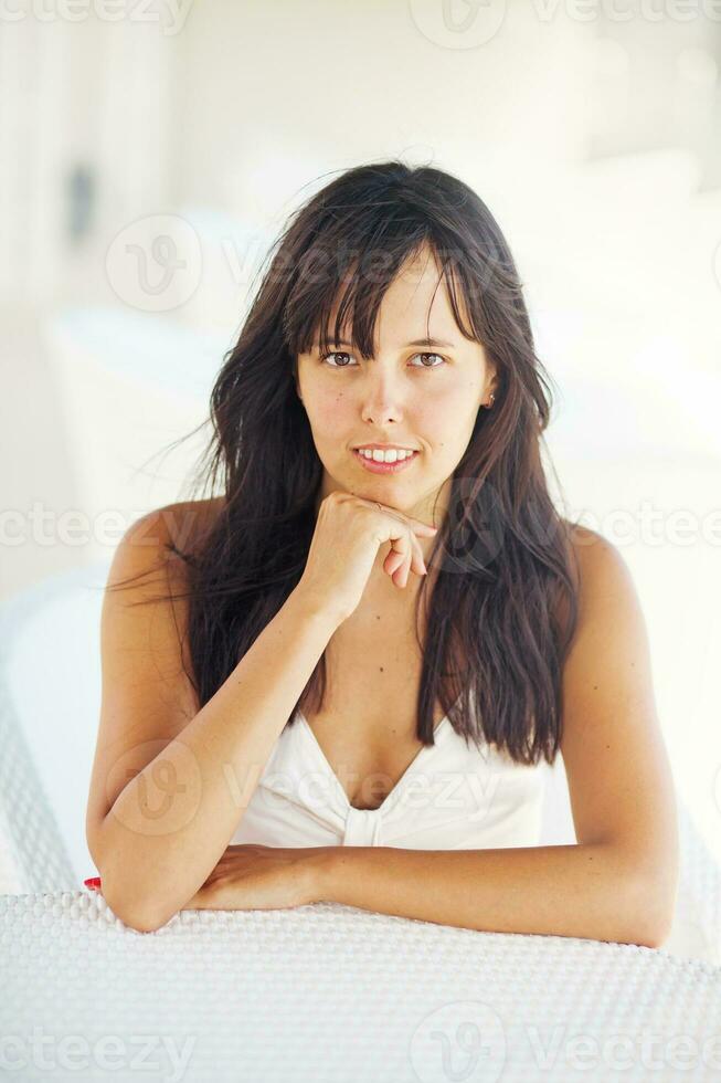 a woman sitting on a white chair photo