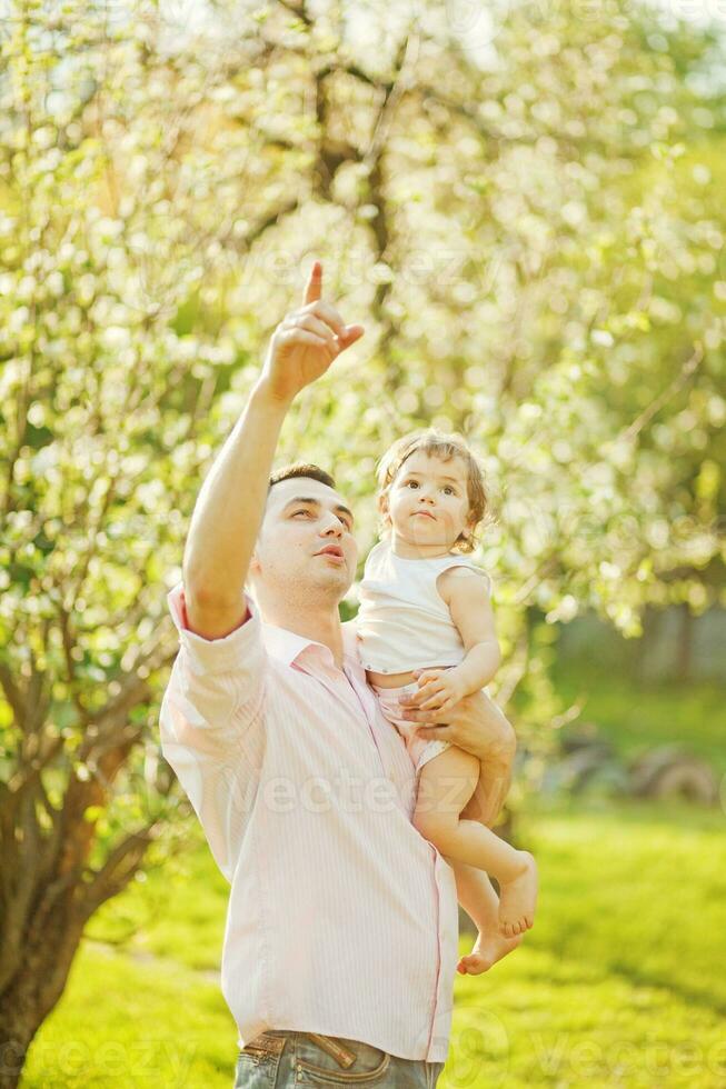 a man holding a baby in the air while pointing photo