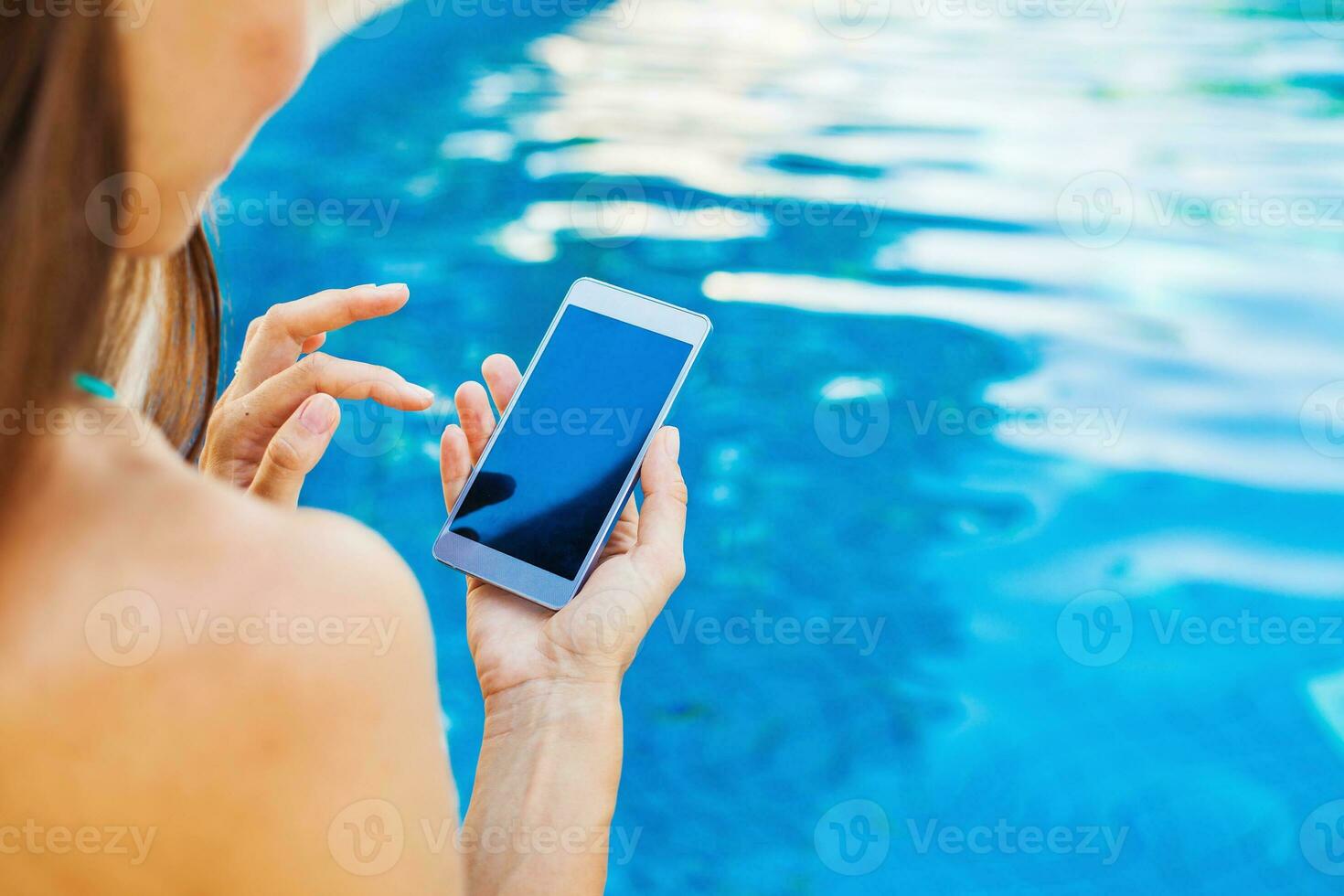 template for a smart phone app woman using her phone while sitting at poolside photo