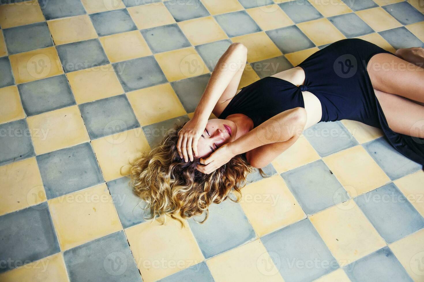 a woman laying on the floor with her head in her hands photo