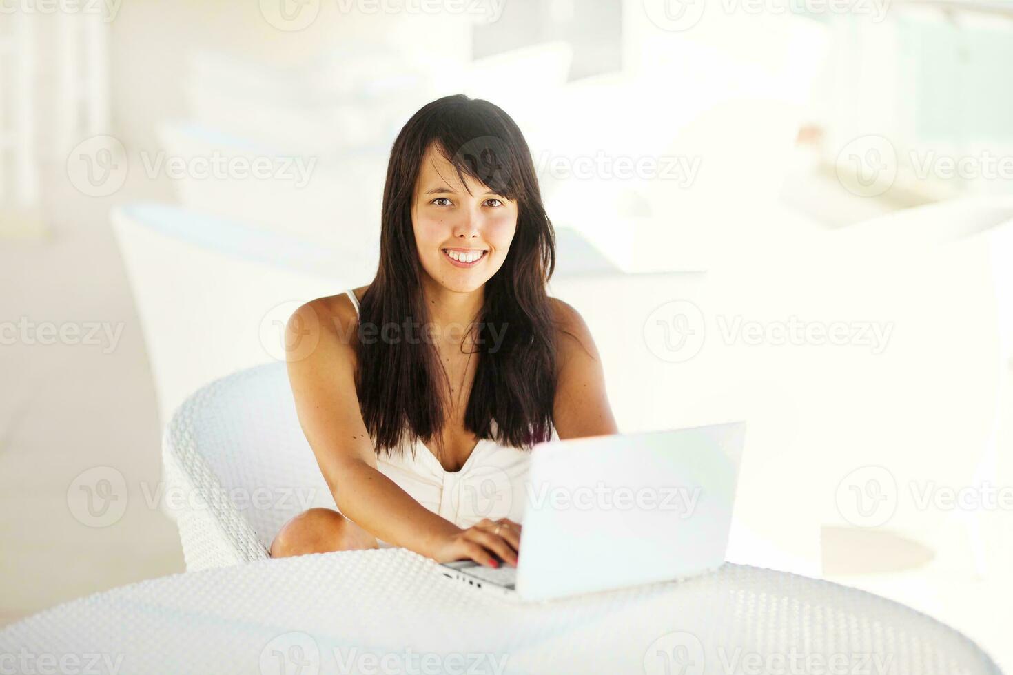 a woman sitting in a chair with a laptop photo