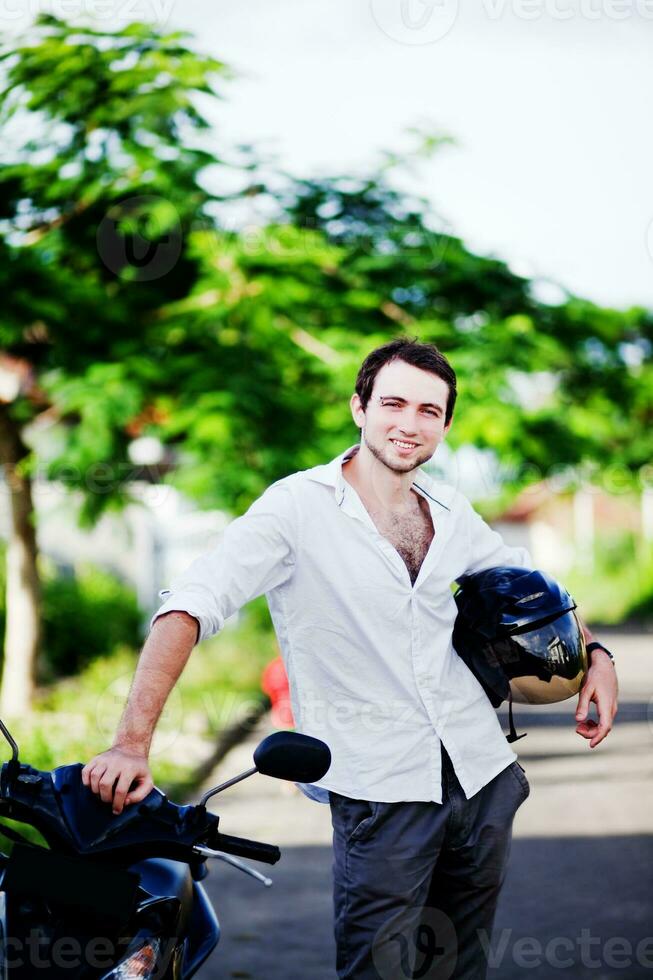 a man standing next to a motorcycle photo