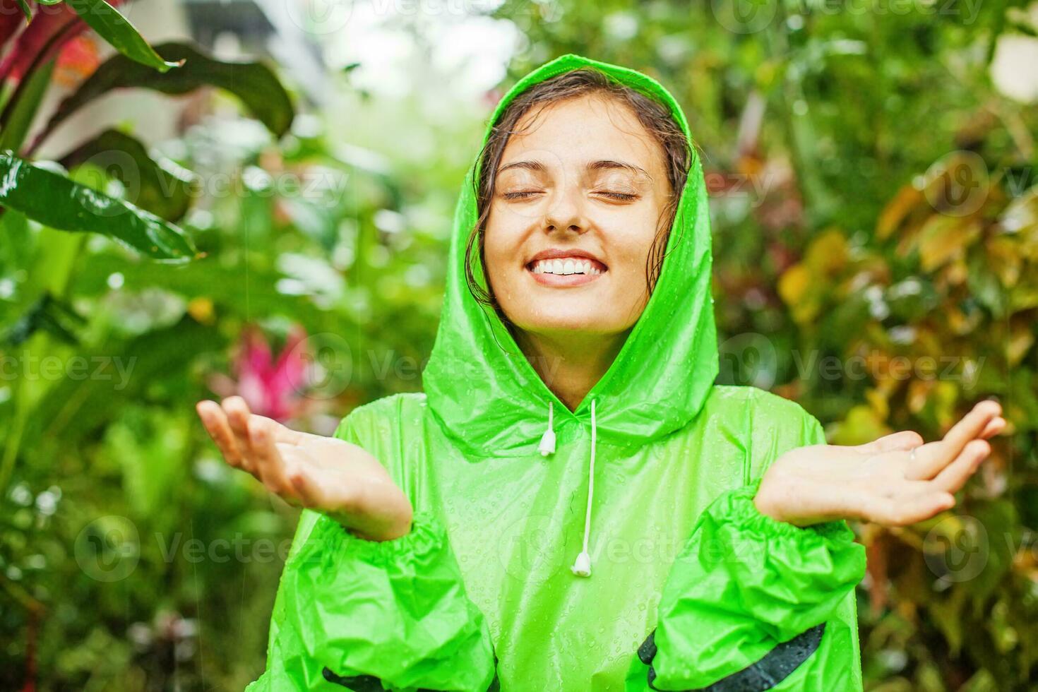 a woman in a green raincoat is smiling photo