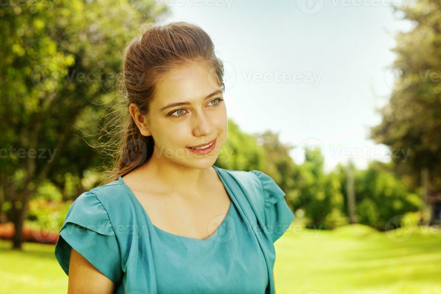 a woman in a blue shirt is standing in a grassy field photo