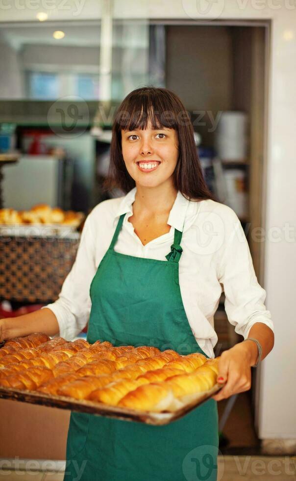 a woman holding a tray of baked goods photo