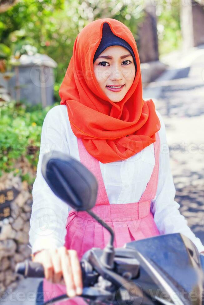 Muslim asian woman riding a motorcycle photo