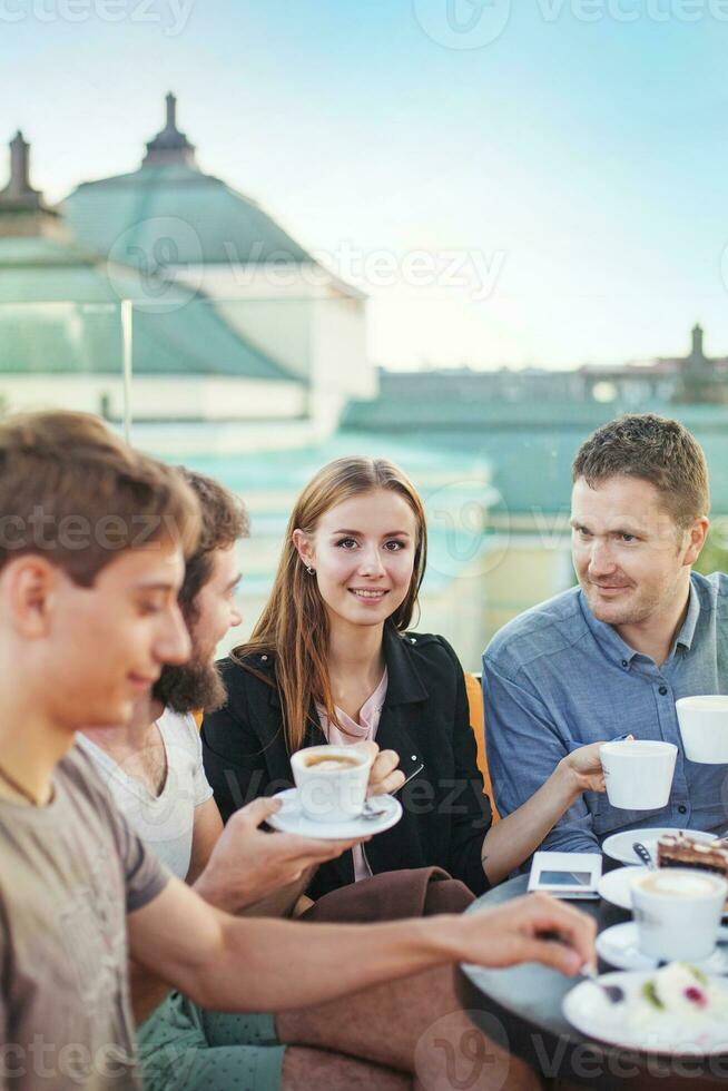 a group of people sitting at a table with coffee photo