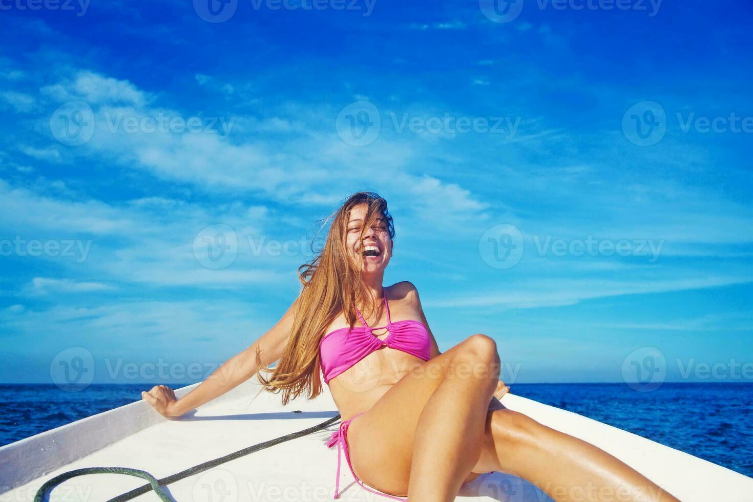 Woman relaxing on a boat and laughing photo