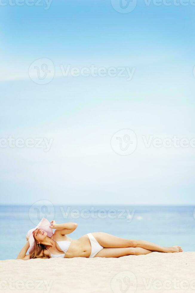 hermosa mujer en blanco bikini en playa con sombrero foto