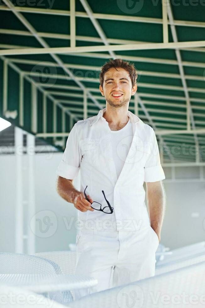a man in white clothes standing in front of a table photo